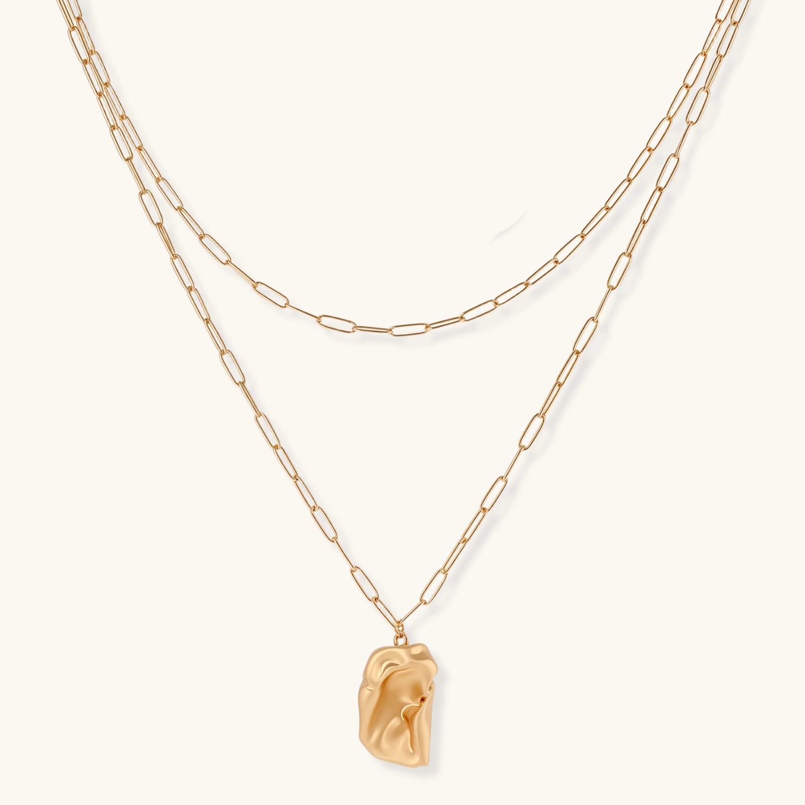 Layered paperclip chain necklace with organic flowing pendant made from eco-zinc alloy in warm gold finish